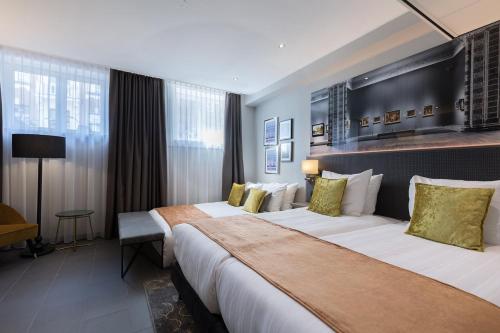 a hotel room with two beds and a desk at Leonardo Boutique Museumhotel in Amsterdam