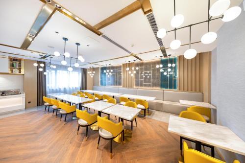 une salle à manger avec des chaises et des tables jaunes dans l'établissement Paco Hotel Guangzhou South Railway Station Panyu Changlong Branch, à Canton