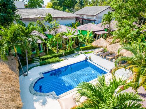 an aerial view of a resort swimming pool with palm trees at Avocado Koh Samui in Bophut