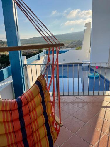 eine Hängematte auf einem Balkon mit Poolblick in der Unterkunft Chemsy Loft in Marina Smir