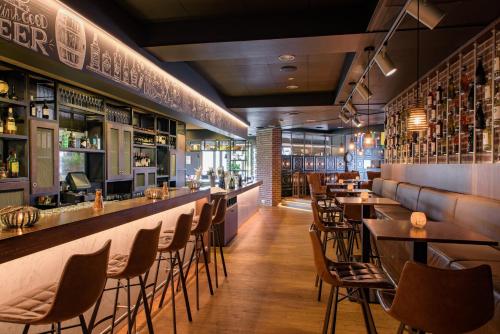 a bar with chairs and tables in a restaurant at Leonardo Hotel Papendrecht in Papendrecht