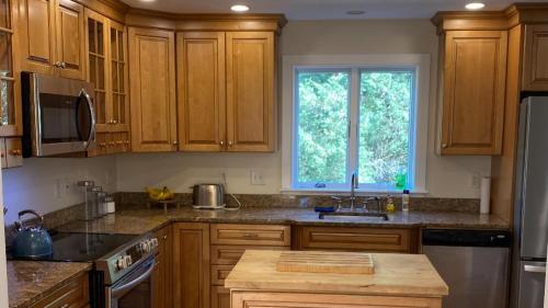 uma cozinha com armários de madeira e uma janela em Home in Oak Bluffs em Oak Bluffs