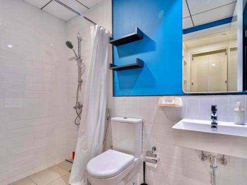 een badkamer met een toilet, een wastafel en een spiegel bij 3BDRM Near Metro for Family&Group in Dubai