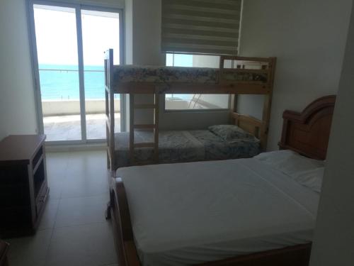 two bunk beds in a room with a view of the ocean at Apartment (Grand Diamond Beach) Tonsupa in Tonsupa