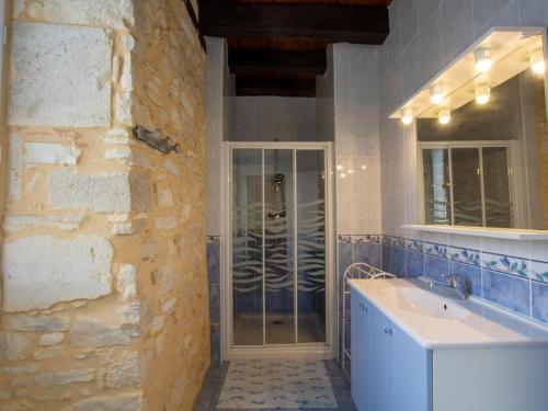 a bathroom with a sink and a stone wall at Maison en pierres avec jardin clos, proche grotte de Tourtoirac, équipements bébé, animaux acceptés. - FR-1-616-280 in Tourtoirac