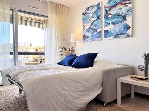 um quarto com uma cama grande e almofadas azuis em Appartement Bormes-les-Mimosas, 1 pièce, 3 personnes - FR-1-251-494 em Bormes-les-Mimosas