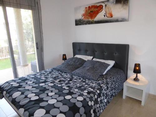 Schlafzimmer mit einem schwarzen und weißen Bett und einem Fenster in der Unterkunft Apartamento Llançà, 2 dormitorios, 4 personas - ES-228-137 in Llança