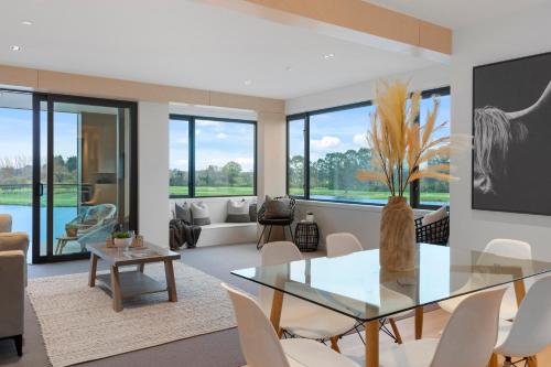 a living room with a glass table and chairs at Clearwater Quays Apartments in Christchurch