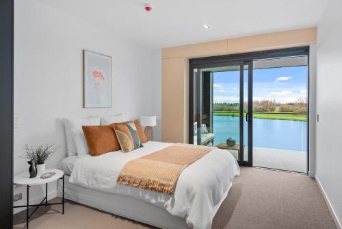 a bedroom with a bed with a view of the water at Clearwater Quays Apartments in Christchurch