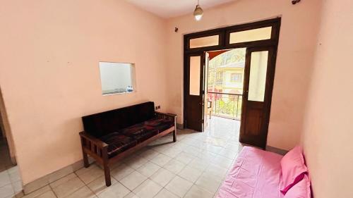 a living room with a couch and a window at Muffys Apartment in Old Goa