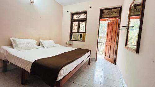 a bedroom with a bed and a window at Muffys Apartment in Old Goa