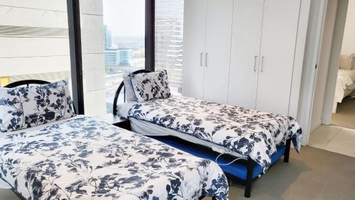 a bedroom with two beds and a window at ◈Melbourne CBD 2Br 2Bth Apt Indoor Pool & balcony◈ in Melbourne
