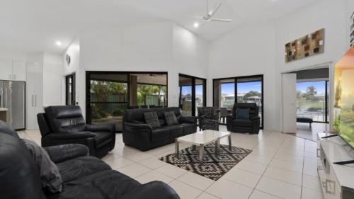 a living room with a couch and chairs and a table at Canal Serenity Retreat in Banksia Beach
