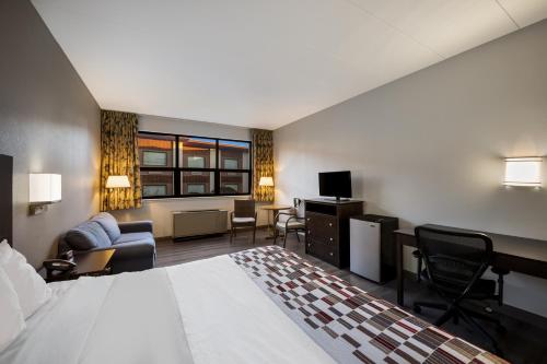 um quarto de hotel com uma cama e uma sala de estar em Gateway Inn em Merrick