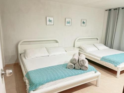 Dos camas en una habitación con toallas. en Espectaculares Aptos Hansa Coral San Andres Islas en San Andrés