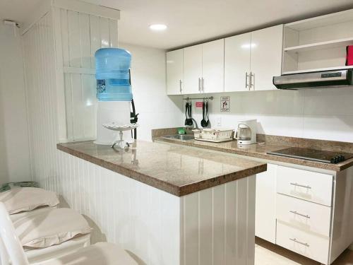 uma cozinha com armários brancos e uma bancada em Espectaculares Aptos Hansa Coral San Andres Islas em San Andrés