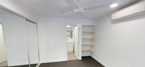 um quarto com paredes e prateleiras brancas e uma janela em Unit 3 - Manly Boutique Apartments em Brisbane
