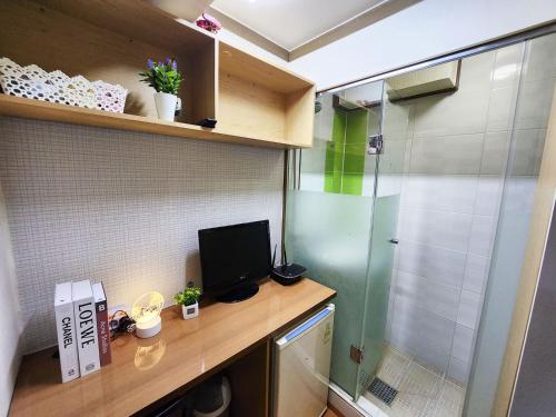 a bathroom with a desk with a television and a shower at Asan Residence in Seoul