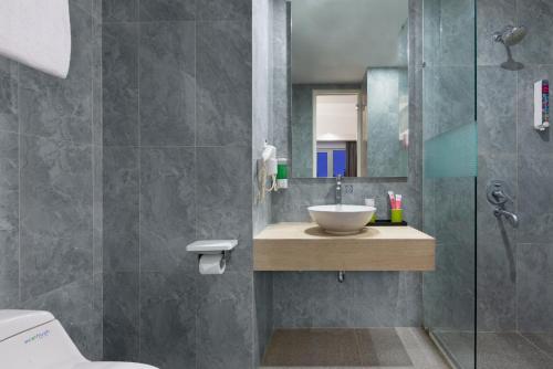 a bathroom with a sink and a shower at favehotel Cilacap in Cilacap