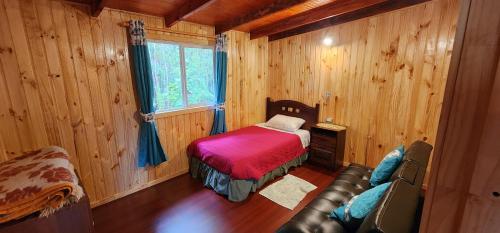 um quarto com uma cama e um sofá num quarto em Cabañas el Cobre - Hornopirén em Hornopirén