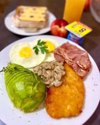 a plate of breakfast food with eggs meat and vegetables at Swane’s guesthouse. in Rustenburg