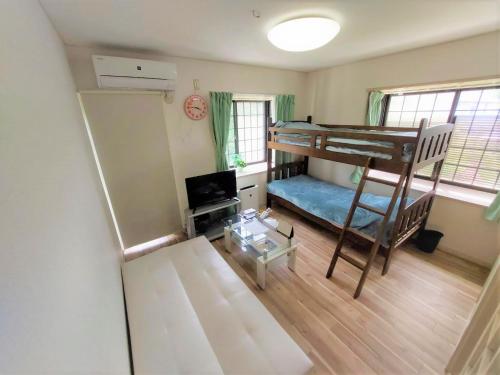 ein kleines Zimmer mit einem Etagenbett und einem Sofa in der Unterkunft Comfort CUBE PHOENIX S Kumamoto in Kumamoto