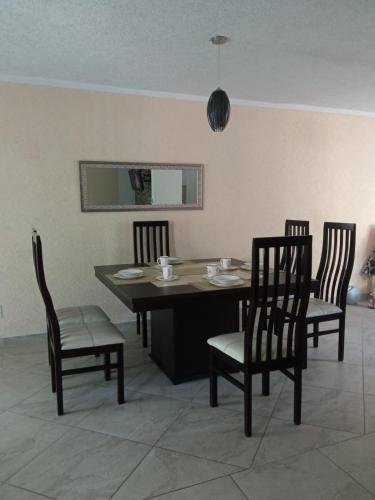 a dining room with a table and four chairs at Casa Confortable in La Sabana