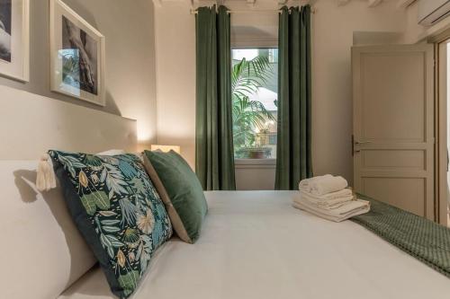 - une chambre avec un lit doté de rideaux verts et d'une fenêtre dans l'établissement Laura Five Senses, à Florence
