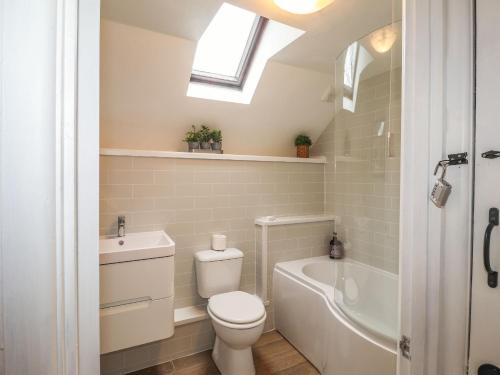 a bathroom with a toilet and a sink and a bath tub at 1 The Barn in Haverfordwest