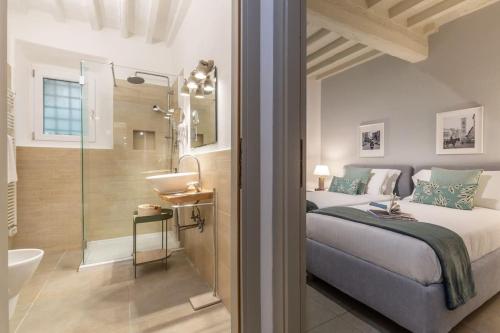 - une chambre avec un lit et une salle de bains pourvue d'une douche dans l'établissement Laura Five Senses, à Florence