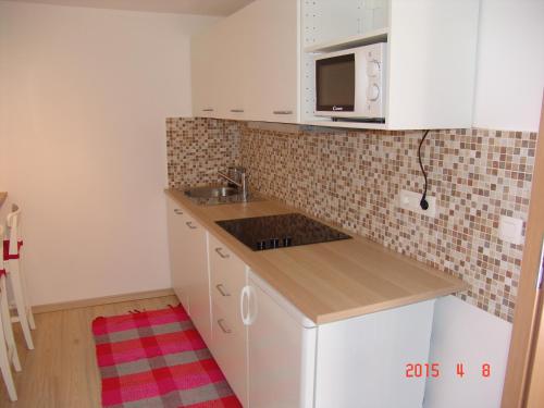 a small kitchen with a sink and a microwave at Apartments Lana in Bled