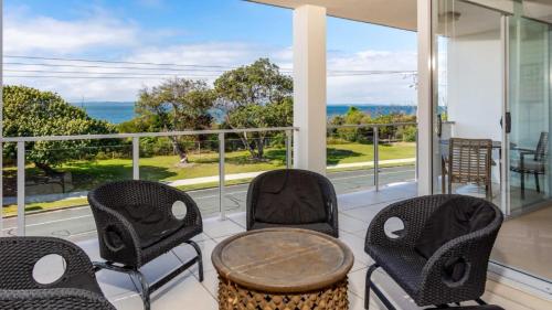 - une terrasse couverte avec des chaises et une table et une vue sur l'océan dans l'établissement Indulge In Ocean Views & Luxury!, à Woorim