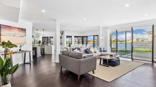 a living room with a couch and a table at Opulent Canal-Front Retreat in Banksia Beach