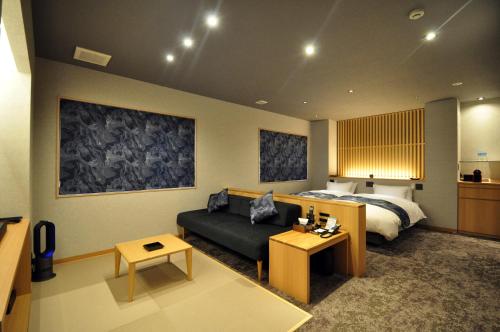 a living room with a bed and a couch in a room at Obokekyo Mannaka in Miyoshi