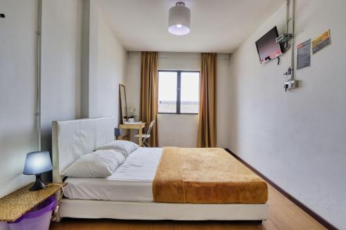 a bedroom with a large bed and a window at Bata Merah Boutique Hotel in Banting