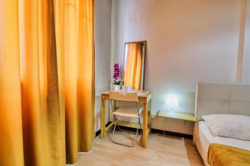 a bedroom with orange curtains and a table and a bed at Bata Merah Boutique Hotel in Banting