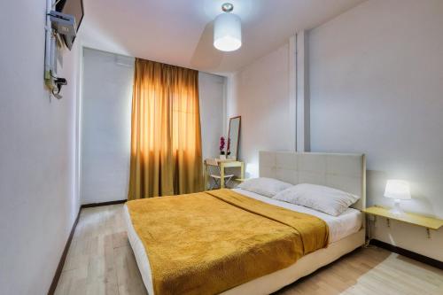 una camera da letto con un grande letto con una coperta gialla di Bata Merah Boutique Hotel a Banting