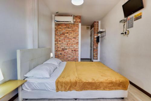a bedroom with a bed and a brick wall at Bata Merah Boutique Hotel in Banting
