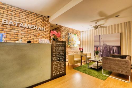 a restaurant with a brick wall and a table at Bata Merah Boutique Hotel in Banting