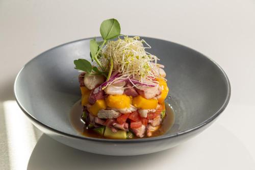 a bowl of food with fruit and greens on it at Holiday Inn Tlaxcala by IHG in Tlaxcala de Xicohténcatl