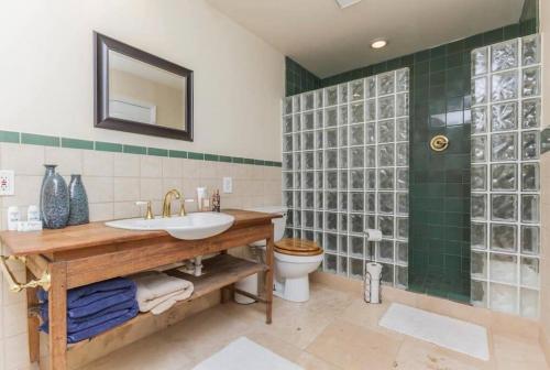 baño con lavabo, aseo y azulejos verdes en Admiral Suite, en St. Augustine