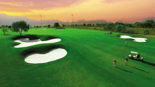 an overhead view of a golf course with people playing at Aamby Valley City in Lonavala