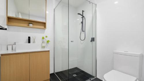 a bathroom with a shower and a toilet and a sink at Anchors Away - Waterfront Unit in Sandstone Point