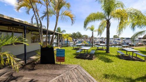 a group of picnic tables and palm trees in front of a marina at Anchors Away - Waterfront Unit in Sandstone Point