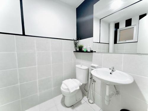 a white bathroom with a toilet and a sink at Alanis Suite With Netflix @ KLIA Sepang in Sepang