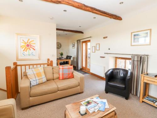 a living room with a couch and a chair at Swallow's Nest in Penrith