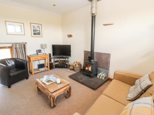 a living room with a couch and a fireplace at Swallow's Nest in Penrith