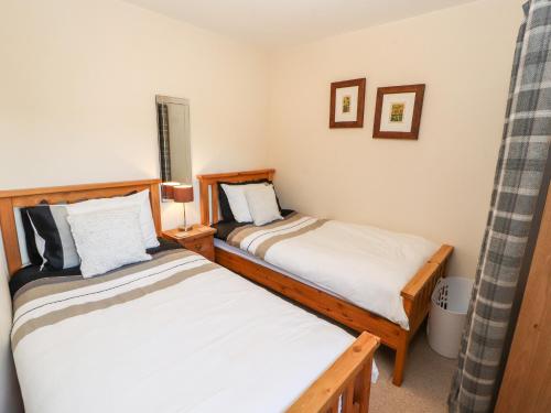 two beds in a small room withermottermott at Swallow's Nest in Penrith