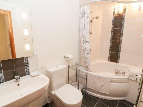 a bathroom with a toilet and a sink and a tub at Swallow's Nest in Penrith