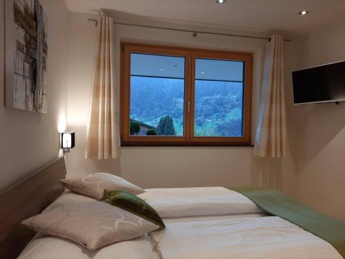 1 Schlafzimmer mit 2 Betten und einem Fenster in der Unterkunft Bergmomente Montafon Appartement St. Gallenkirch in Sankt Gallenkirch